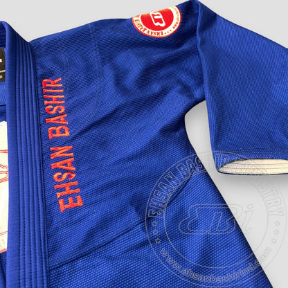 Ehsan Bashir Industry blue cotton Jiu Jitsu Gi with orange embroidery on the lapel and sleeve. Features reinforced stitching and a textured weave.
