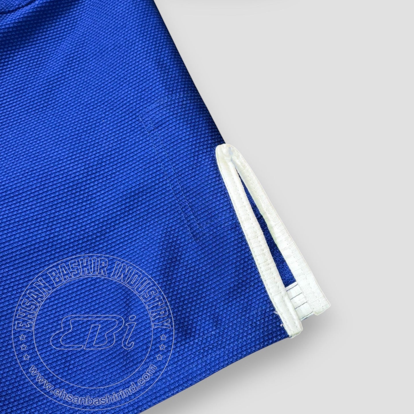 Ehsan Bashir Industry blue cotton Jiu Jitsu Gi with reinforced stitching and white trim.